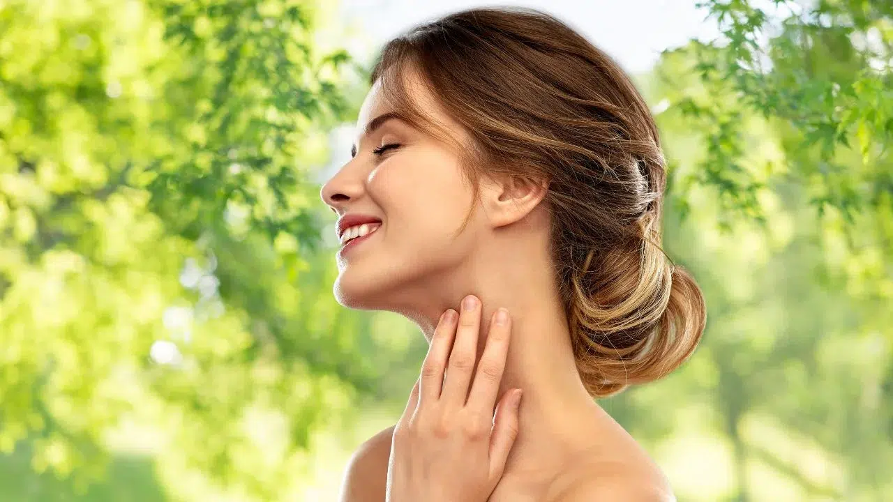 smiling young woman touching her neck
